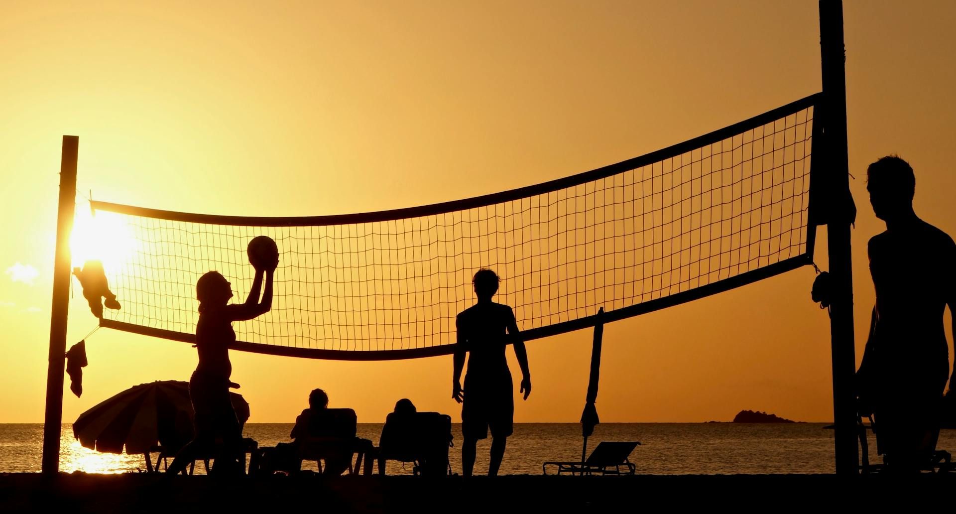 Beach volleyball at sunset.