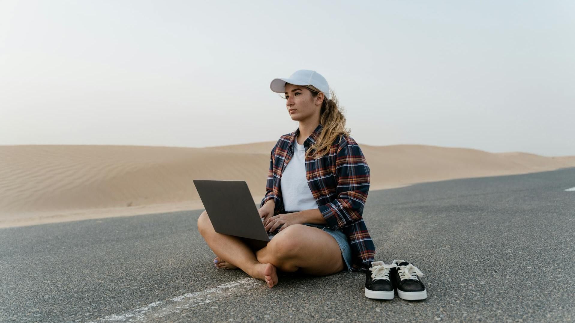 Girl with a laptop in the desert.
